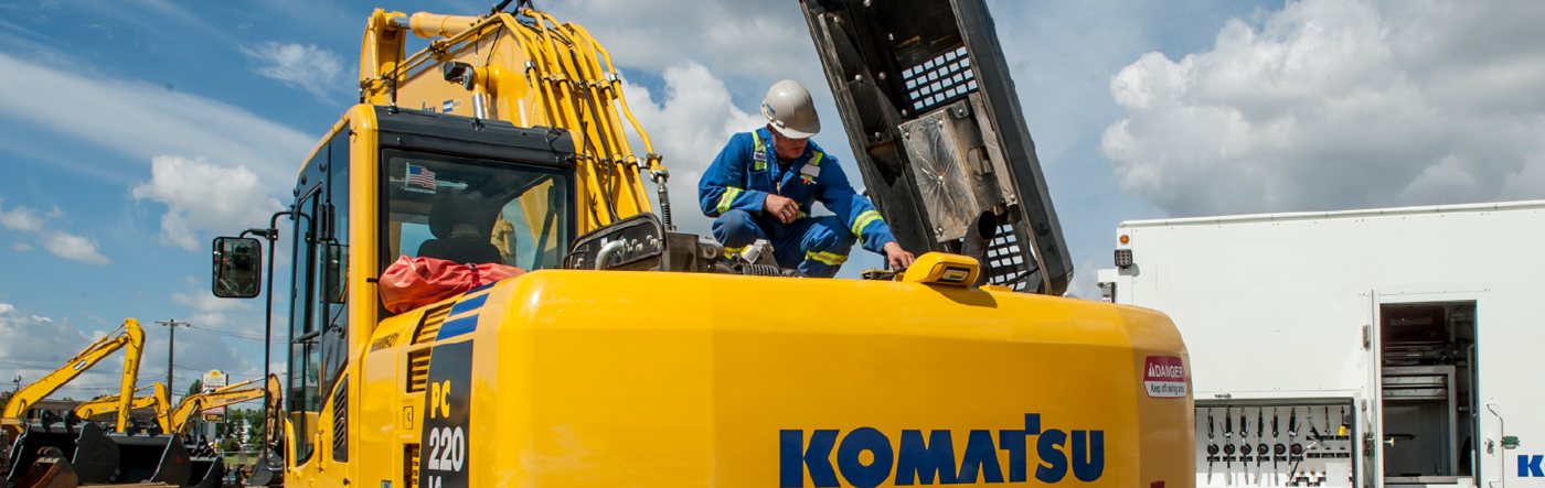 Worker inspecting construction equipment